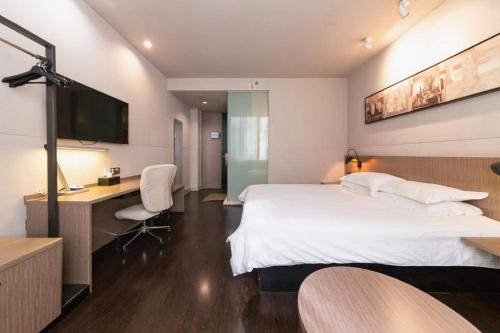 a hotel room with a bed and a desk and a tv at Jinjiang Inn Xi'an Zhonglou North Street Metro Station in Xi'an