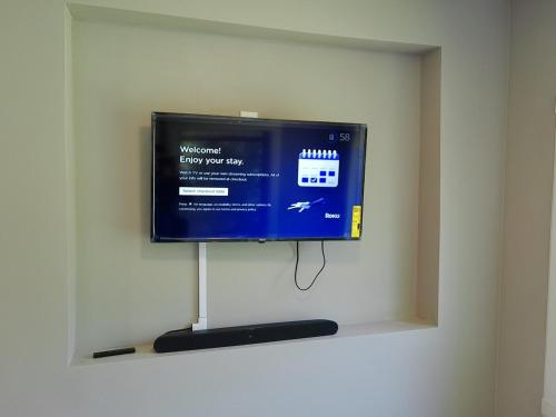 a flat screen tv sitting on a wall at King Bed Creekfront Retreat in Jacksonville in Jacksonville