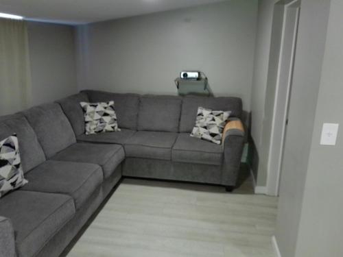 a living room with a gray couch in a room at King Bed Creekfront Retreat in Jacksonville in Jacksonville