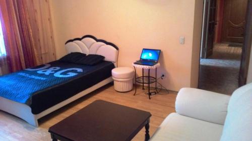 a bedroom with a bed and a laptop on a table at Apartments on Kommunisticheskaya 25 in Saransk