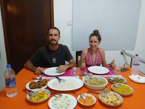 a man and a woman sitting at a table with food at SILVER RAIL in Galle
