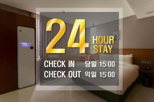 a sign in a window of a room with a bed at Top Cloud Hotel Iksan in Iksan