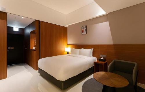 IksanTop Cloud Hotel Iksan的一间带床和椅子的酒店房间