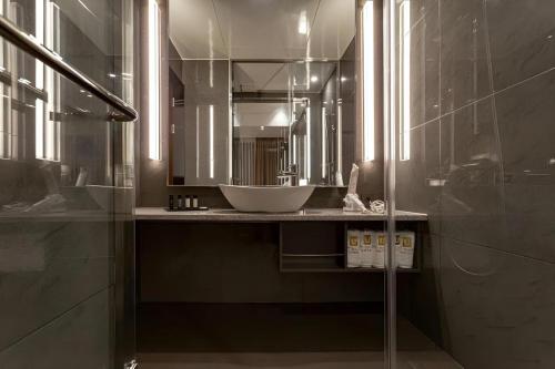 a bathroom with a sink and a large mirror at Top Cloud Hotel Iksan in Iksan