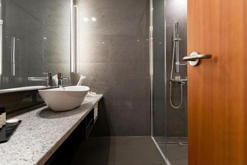 a bathroom with a sink and a glass shower at Top Cloud Hotel Iksan in Iksan