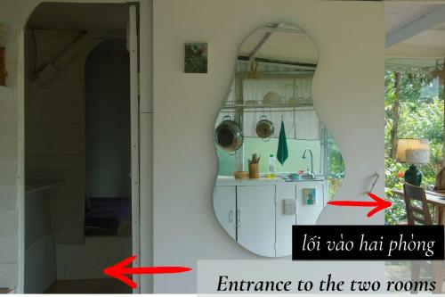 an open door with a mirror and an entrance to the two rooms at Cú Trên Cây Homestay in Xuan An