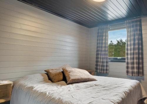 Schlafzimmer mit einem Bett und einem Fenster in der Unterkunft Mortenhytta, Valevåg in Valevåg