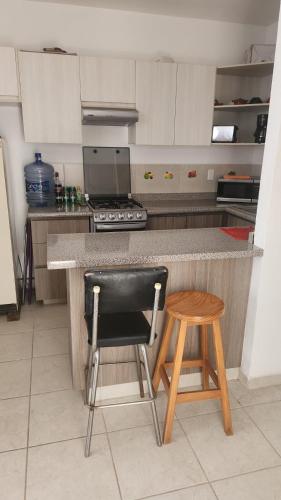 a kitchen with a black chair and a counter at La escondida del mar in Valente Díaz y La Loma