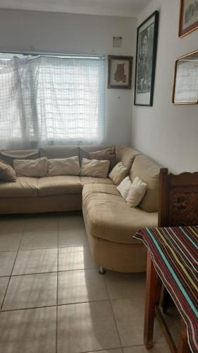 a living room with a brown couch in front of a window at La escondida del mar in Valente Díaz y La Loma