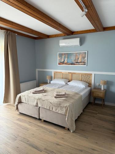 a bedroom with a bed in a room with blue walls at Dom nad Lubiążem in Lubniewice