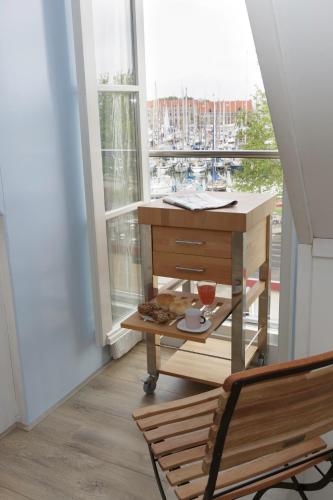 a table and a chair in a room with a window at El Puerto Bed and Breakfast in Hoorn