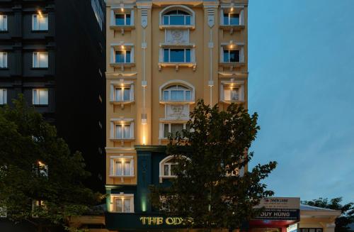 ホーチミン・シティにあるThe Odys Boutique Hotelの前に看板がある高い建物
