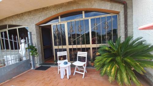 two chairs and a table in front of a door at Casa Fiorita in Ameglia