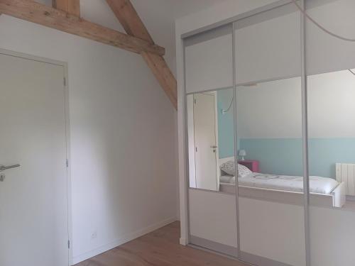 una camera con un mobile in vetro con un letto. di Maison de ville cosy avec jardin, à 300 m de la plage & restaurants a Binic