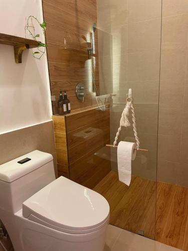 a bathroom with a toilet and a glass shower at Meraki Siargao Resort in General Luna