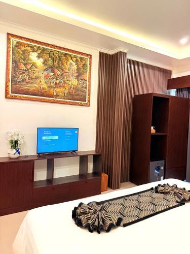 a hotel room with a bed and a tv at Kelingking Tropical in batumadeg