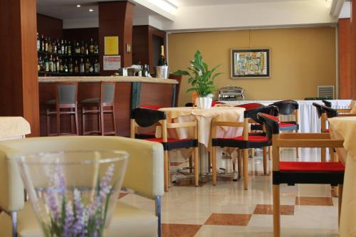 a restaurant with a bar and tables and chairs at Parc Hotel Casa Mia in Lazise