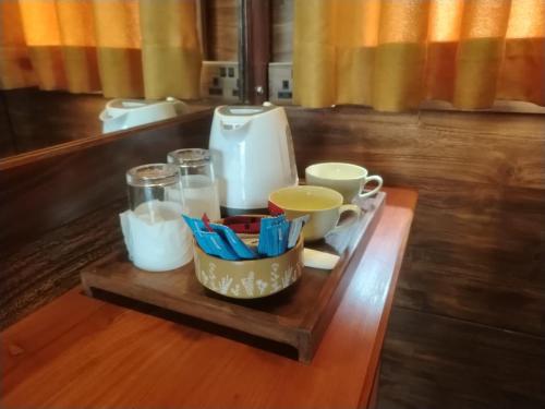 ein Tablett mit Tassen und Bechern auf einem Tisch in der Unterkunft Green Earth Resort in Dambulla