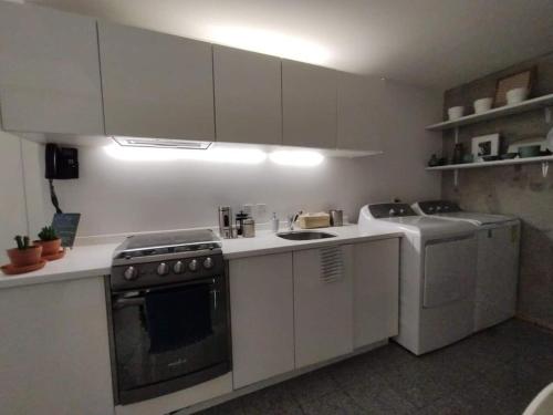 a kitchen with white cabinets and a stove top oven at Cute Condesa Studio Indoor Pool Nice Gym in Mexico City