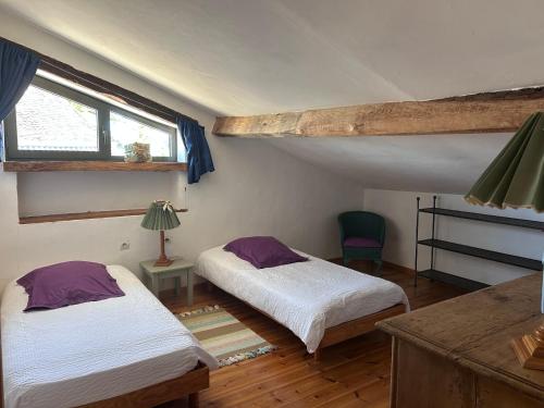 a bedroom with two beds and a window at Domaine Le Rolant in Montaut