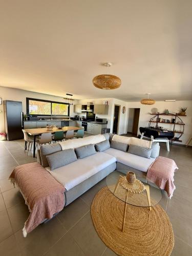 a living room with two couches and a table at Villa de Luxe avec Piscine à débordement chauffée à Porticcio in Porticcio