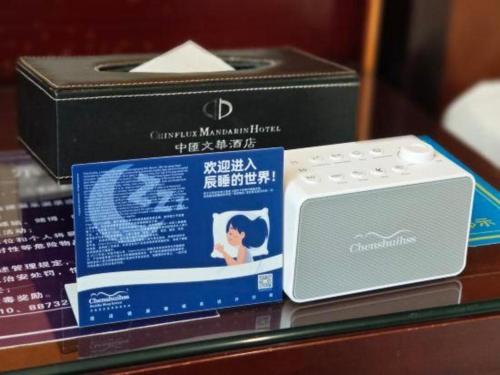 a box and a radio sitting on a table at Chinflux Mandarin Hotel in Dongguan