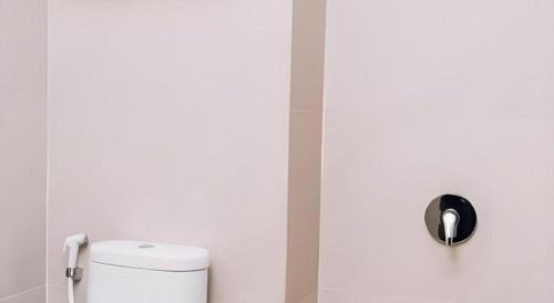 a white bathroom with a toilet in a room at HOTEL GRAND KUTILANG SYARIAH in Bandar Lampung