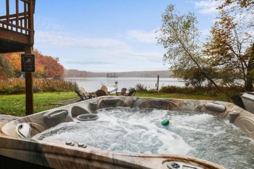 a hot tub with water in it next to a lake at Lake Front, Ski,hot Tub, Fire Pit, Fp, Boats in Gouldsboro