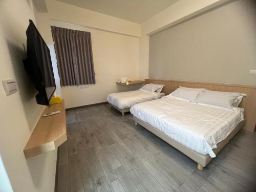 a bedroom with two beds and a flat screen tv at 伊勾瑞行旅 in T'ung-ko