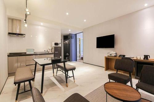 a living room with a table and chairs and a kitchen at Gimhae Perfect Hotel in Gimhae