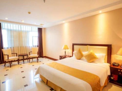a hotel room with a bed and a table and chairs at Guangzhou Jing Yi hotel in Huadu