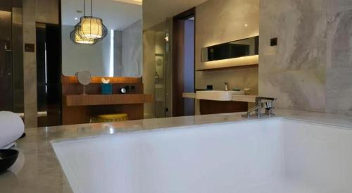 a large bathroom with a sink and a large tub at Chongqing The Lotus Hotel in Chongqing