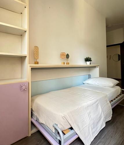 a bedroom with two beds and a shelf at 2 bed Flat near Metro of Sesto San Giovanni in Sesto San Giovanni
