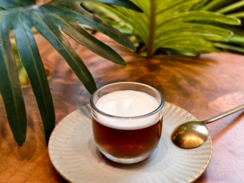a glass of milk on a plate with a spoon at SI Hotel in Taichung