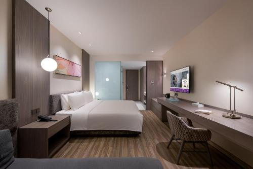 a hotel room with a bed and a desk at Mercure Shanghai Hongqiao South in Shanghai