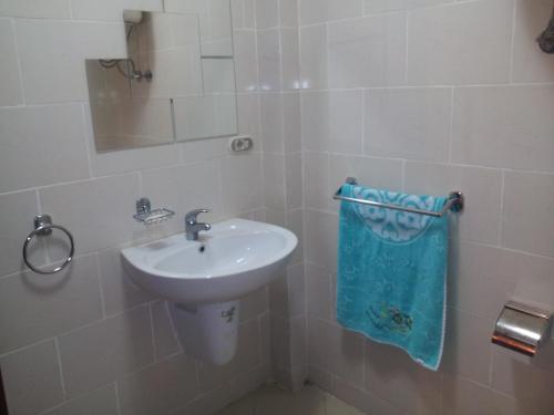 a white bathroom with a sink and a mirror at Apartment in Golf Porto Marina in El Alamein