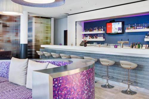 a bar with a purple counter and stools at IntercityHotel Rostock in Rostock