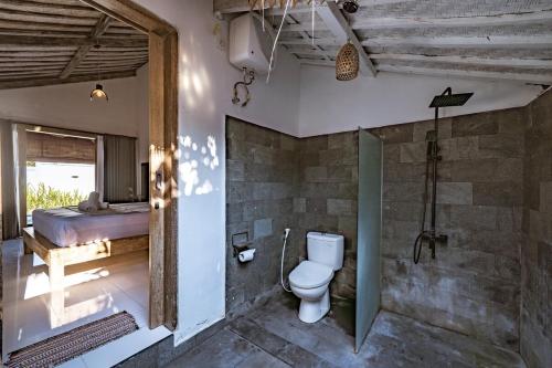 a bathroom with a toilet in a room at Villa La Luna 2BR Joglo Style with Pool by Damaresa in Dalung
