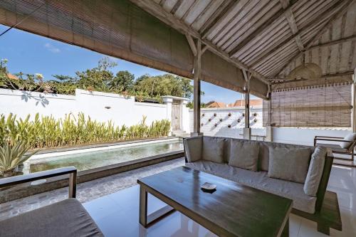 a living room with a couch and a table at Villa La Luna 2BR Joglo Style with Pool by Damaresa in Dalung