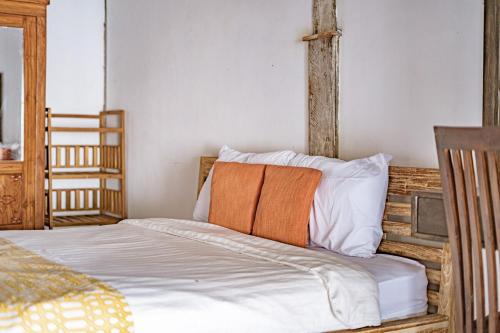 a bedroom with a bed with an orange blanket at Villa La Luna 2BR Joglo Style with Pool by Damaresa in Dalung