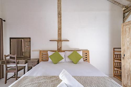 a bedroom with a bed and a desk and a chair at Villa La Luna 2BR Joglo Style with Pool by Damaresa in Dalung