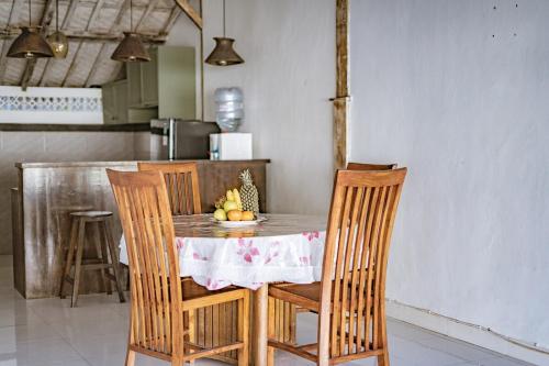 a table with chairs and a table with fruit on it at Villa La Luna 2BR Joglo Style with Pool by Damaresa in Dalung