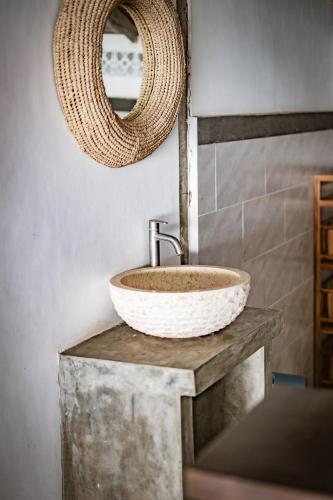 a bathroom with a sink and a mirror at Villa La Luna 2BR Joglo Style with Pool by Damaresa in Dalung