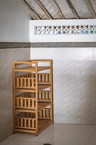 a wooden shelf in a room with a wall at Villa La Luna 2BR Joglo Style with Pool by Damaresa in Dalung