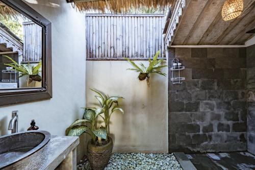 a bathroom with a sink and a shower with plants at Villa La Luna 2BR Joglo Style with Pool by Damaresa in Dalung