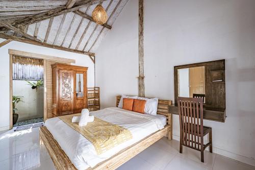 a bedroom with a bed and a wooden chair at Villa La Luna 2BR Joglo Style with Pool by Damaresa in Dalung