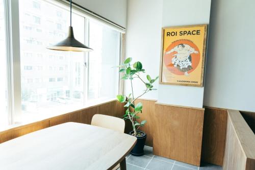 鹿児島市にあるROI SPACE KAGOSHIMAの白いテーブルとポスターのあるダイニングルーム