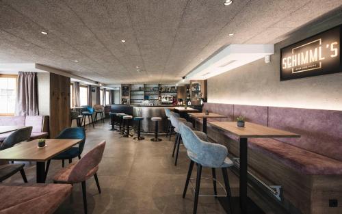 a restaurant with tables and chairs and a bar at Hotel Schölzhorn Superior in Racines