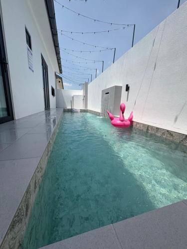 クアンタンにあるThe Noice Villa Private poolのプールでピンク色のカヤックに乗っている人