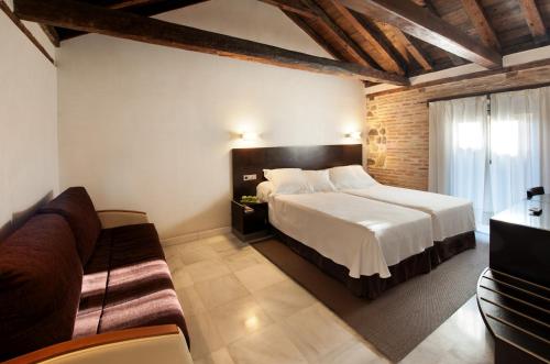 a bedroom with a large bed and a couch at Pintor El Greco in Toledo